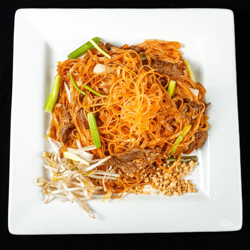 Thai Chilli Pepper's Pad See Ew with beef, bean sprouts, peanuts, and green onions.